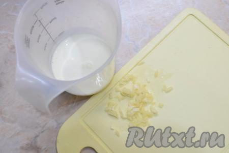 Пока блюдо тушится, подготовьте необходимое количество жирных сливок. Если использовать сливки малой жирности, то соус получится достаточно жидким. Чеснок очистите и очень мелко порубите ножом.