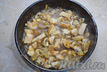 Влейте в сковороду горячую воду, дайте закипеть, а затем тушите индейку с шампиньонами под крышкой на небольшом огне минут 15. За время готовки часть воды выкипит.