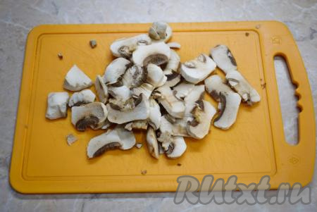 Свежие шампиньоны промойте в проточной воде и очистите от внешних плёночек. Затем нарежьте шампиньоны на ломтики.