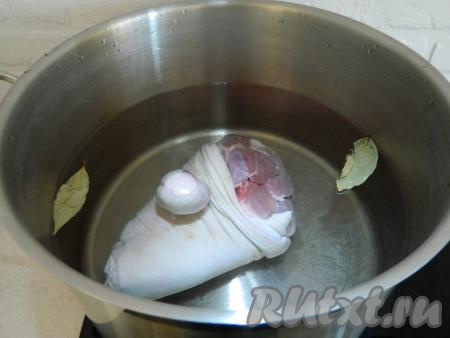 Далее помещаем рульку в большую кастрюлю, заливаем её полностью водой, добавляем 1 очищенную луковицу, 2 лавровых листа, соль по вкусу и ставим на плиту на максимальный огонь. После закипания снимаем пенку, уменьшаем огонь и варим на медленном огне 1,5 часа.