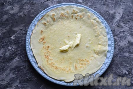 Пока блины горячие, каждый смазывать кусочком сливочного масла.