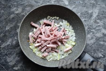 Очищенную луковицу нарезать мелкими кусочками, обжарить на растительном масле, помешивая, до мягкости на среднем огне. Затем к обжаренному луку добавить нарезанную брусочками варёную колбасу.