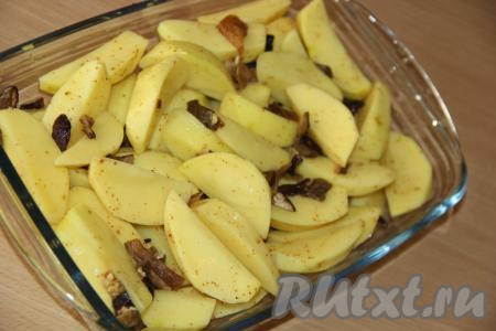 Посолить картошку, можно добавить щепотку специй для картофеля. В жаропрочную форму выложить дольки картофеля и разровнять. Я ещё добавила пару горсточек сушёных грибов (грибы предварительно нужно промыть под горячей водой и мелко нарезать), но грибочки можно и не добавлять.