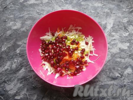 В салат из капусты, морковки и лука добавить заправку и половину зёрен граната.
