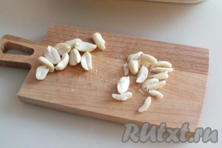 Очищенный арахис разрежьте ножом вдоль ядрышка на продолговатые кусочки.