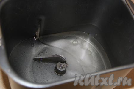 В ведёрко хлебопечки влить воду комнатной температуры и растительное масло, сюда же добавить соль и сахар.
