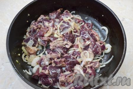 Затем выложите нарезанную куриную печень в сковороду к луку. Перемешайте и обжаривайте печёнку с луком на небольшом огне минут 10, накрыв крышкой, и периодически перемешивая. Куриная печень готовится очень быстро. Для проверки готовности разрежьте самый большой кусочек и посмотрите на разрез. Он должен быть равномерно серого цвета, без красноты. Для надёжности подержите на огне ещё пару минут, периодически перемешивая.