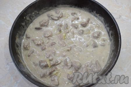Влейте сметанный соус в сковороду с куриной печенью, обжаренной с луком, и, помешивая, доведите до кипения. При нагревании соус немного загустеет. Добавьте соль и специи по вкусу. Затем тушите в течение 3-5 минут под крышкой на небольшом огне.