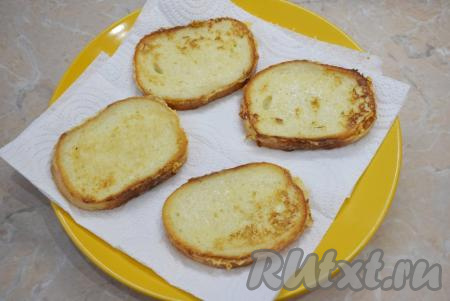 Гренки должны стать аппетитного золотистого цвета. Обжаренные кусочки батона переложите со сковороды на бумажное полотенце, чтобы удалить лишнее масло.