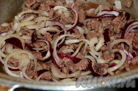 Нарезать лук репчатый кольцами и добавить к мясу.