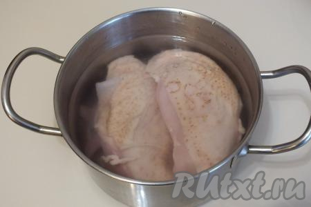 Куриное филе вымойте, переложите в кастрюлю, залейте, примерно, 600 мл холодной воды, поставьте на огонь и после закипания, убрав пену, отварите на небольшом огне в течение 30 минут (до готовности).