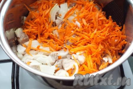 Когда свинина начнёт слегка покрываться корочкой, добавьте нарезанный лук и натёртую морковь, перемешайте и обжаривайте мясо с овощами в течение 15 минут, периодически помешивая и не допуская пригорания.