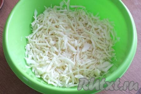Пока мясо обжаривается с овощами, нарежьте капусту тонкой соломкой, переложите в миску, добавьте щепотку соли и хорошо помните руками, чтобы она стала более сочной.