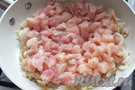 Когда лук начнёт слегка румяниться, добавьте нарезанное куриное мясо.