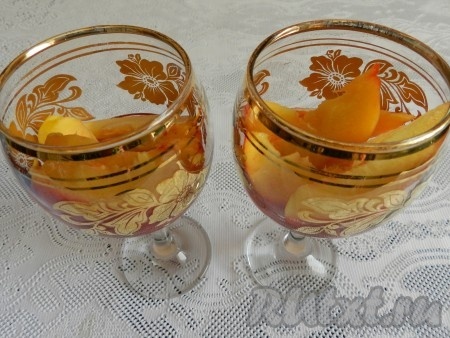 На дно бокалов (или креманок) налить немного малинового пюре, разложить дольки персиков.
