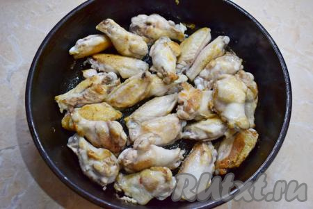 Для приготовления берите большую сковороду с широким дном и высокими бортиками. Разогрейте её до горячего состояния и налейте немного растительного масла. Выложите подготовленные крылышки и обжарьте их на сильном огне с двух сторон до румяного цвета, иногда помешивая. На это уйдёт минут 5-7.