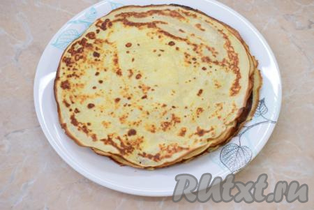 Готовый румяный блинчик выложите на тарелку. А из оставшегося теста пожарьте аналогично оставшиеся блины, складывая их стопочкой на тарелку.