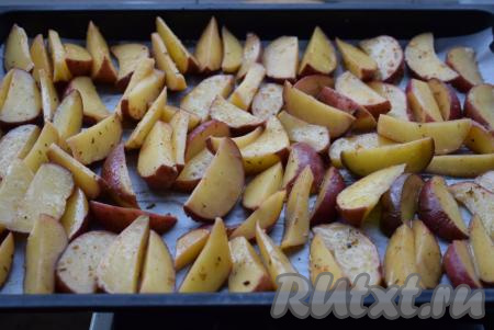 Противень застилаем пергаментом и раскладываем на него картофельные дольки, стараемся, чтобы они лежали как бы отдельно друг от друга - так картошка равномерно запечётся со всех сторон.