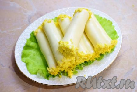 Вот такие красивые рулетики из плавленного сыра пластинками с куриной начинкой получились. Их можно сразу же подавать к столу. Закуска получается и аппетитной, и очень вкусной. Я подала сырные рулетики на отдельной тарелке, выложив на листья салата.