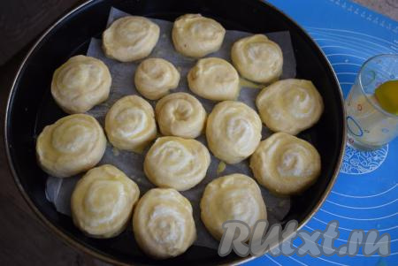 Булочки смазываем взбитым яйцом при помощи кулинарной кисти. Накрываем форму с булочками плёнкой и ставим на расстойку на 35-40 минут.