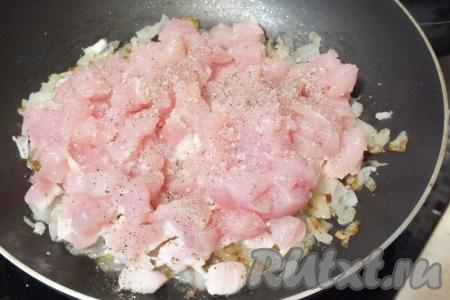 Куриное филе нарежьте кубиками размером не более 1 см, переложите его в сковороду к обжаренному луку, добавьте соль, перец по вкусу. Перемешайте, поставьте на огонь и обжаривайте, периодически помешивая, до "побеления" филе. Как только мясо станет полностью белым, снимайте с огня. Не следует его пережаривать, иначе начинка получится сухой.