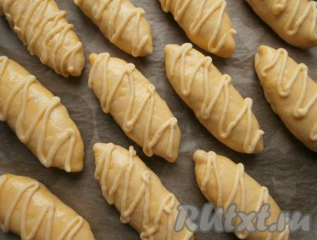 Булочки смазать желтком и нанести на них сверху тонкие полосы заварного крема.