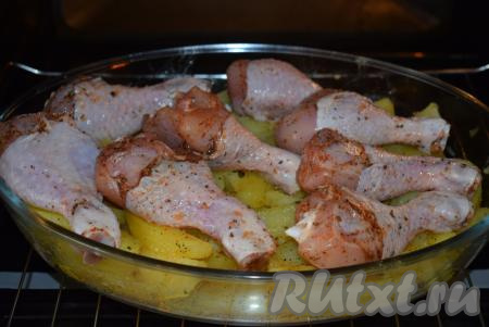 На подготовленный картофель выкладываем куриные голени и отправляем форму в холодную духовку (чтобы стеклянная форма не раскололась), если вы запекаете в металлической форме, то духовку перед запеканием можно разогреть.