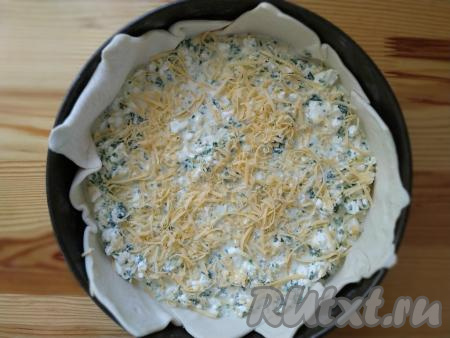 Сверху на тесто выкладываем подготовленную начинку из курицы и шпината, сверху равномерно посыпаем половиной натёртого сыра. Затем равномерно заливаем сметанно-яичной заливкой и присыпаем оставшимся сыром. При желании, украшаем кунжутными семечками.