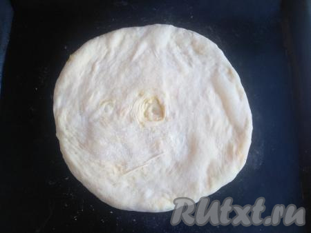 Затем перевернуть узелком вниз и раскатать, стараясь не нарушить целостность теста. В центре теста сделать отверстие для выхода пара (насквозь лепёшку прокалывать не нужно, достаточно будет сделать отверстие, доходя только до начинки). Переложить лепёшку на противень, застеленный антипригарным ковриком (или пергаментом), выпекать в разогретой духовке при температуре 230 градусов в течение минут 15 (до зарумянивания).