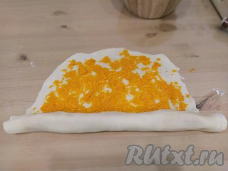 Аналогично раскатываем в тонкие лепёшки оставшиеся части теста. Начинку из тыквы делим на 3 части. Кладём на лепёшку 1/3 часть начинки из тыквы и равномерно распределяем по всей поверхности теста, не доходя до краёв, примерно, 2 см. Сворачиваем лепёшку с тыквой в рулет.