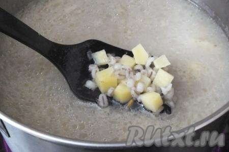 Поставьте кастрюлю с бульоном и перловкой на огонь. Если жидкость сильно выкипела, можно добавить 200 мл воды. Выложите в бульон картофель, доведите до кипения, а затем варите на огне чуть меньше среднего 10-15 минут до готовности картофеля (картошка должна стать мягкой, легко прокалываться ножом).