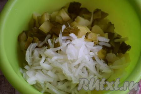 В глубокую миску выложить нарезанные картофель и огурцы. С лука слить всю жидкость и выложить его в миску.