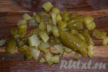 Пока маринуется лук, нарезать солёные огурцы на кубики.