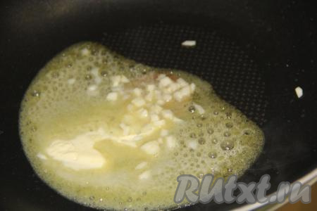 В сковороду с высокими бортиками выложить сливочное масло и растопить. Чеснок почистить, нарезать на мелкие кубики, выложить в растопленное масло и обжарить в течение минуты, помешивая, на среднем огне.
