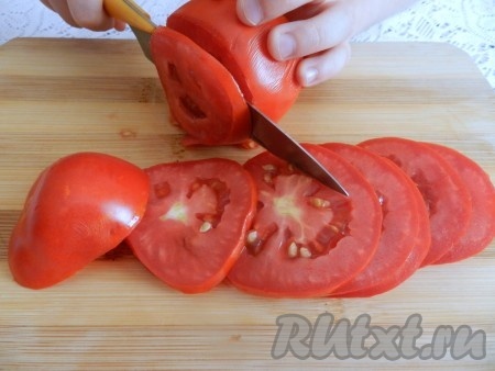 Острым ножом помидоры нарезать на кружочки.