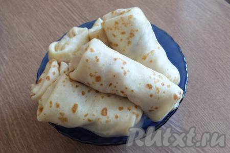 Блины, фаршированные капустой и яйцами, подавайте к столу тёплыми (если они остыли, их можно обжарить на сковороде с двух сторон или подогреть в микроволновке).