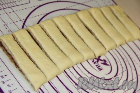 Нарезать тесто на полосы шириной, примерно, 5 см. Это будут заготовки наших булочек.