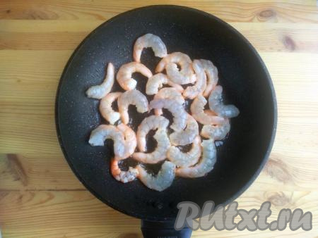 Сковороду с растительным маслом разогреть, выложить королевские креветки в один слой. Обжаривать их в течение 1,5 минут на среднем огне (до розового цвета).