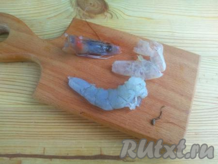 У креветок отделить голову, она нам не понадобится. Снять панцирь, начиная с головы и до хвоста, затем вытянуть тонкую кишечную ниточку, которая располагается со стороны спинки.