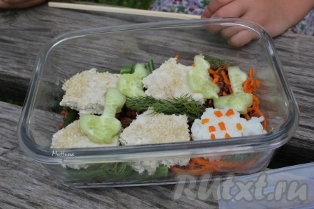 Положите фигурки в контейнер к красному рису, добавьте овощи - фасоль, морковь по-корейски и свежую зелень.
