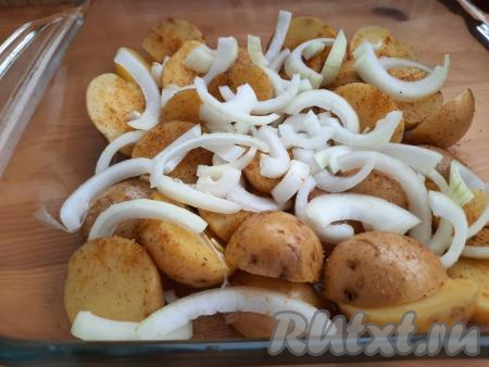 Поверх картошки выложить очищенный и нарезанный полукольцами лук.
