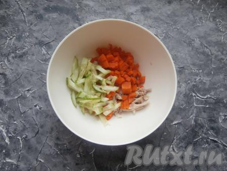 Добавить к куриному мясу нарезанный соломкой свежий огурец и нарезанную кубиками варёную морковку.