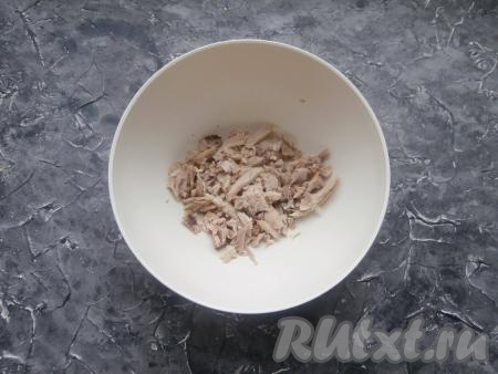 Заранее нужно сварить куриное мясо (варим 30-35 минут с момента закипания воды), яйца (варим около 10 минут с начала кипения воды) и морковку в кожуре (отвариваем в течение минут 20 с начала закипания воды), остудить. Яйца и морковь очистить. Курицу нарезать небольшими кусочками и выложить в салатницу.