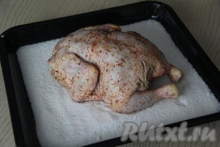 Выложить курицу на соль грудкой вниз.