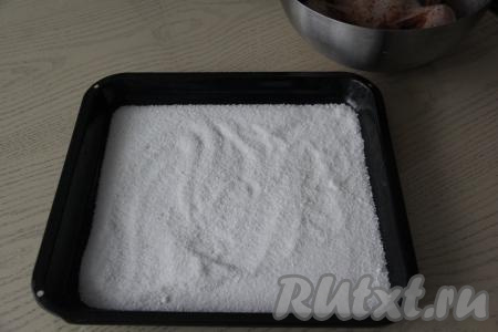 На противень насыпать соль и равномерно распределить.
