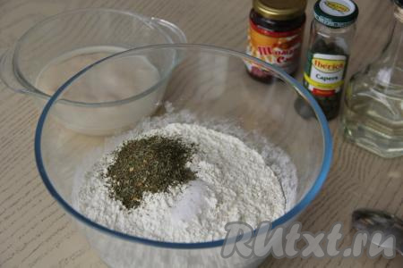 В глубокой миске, удобной для замешивания дрожжевого теста, соединить муку, соль и сушёную зелень, слегка перемешать сухие ингредиенты.