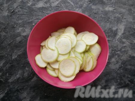 Кабачки молодые (с тонкой шкурочкой и мелкими семечками) нарезать очень тонкими кружочками с помощью специальной тёрки или ножа. Посыпать половиной чайной ложки соли и перемешать.