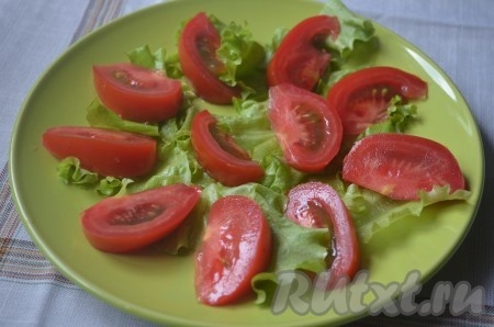 На блюдо выложить листья салата и помидор, порезанный ломтиками.
