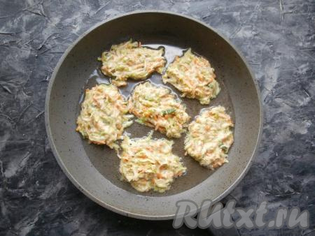 Кабачково-морковную массу столовой ложкой выкладывать в виде оладий на сковороду, очень хорошо разогретую с растительным маслом.