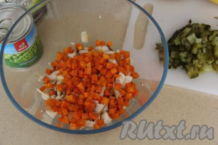 К копчёной треске выложить варёную морковку, нарезанную на кубики.